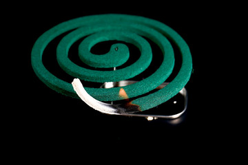 Closeup of mosquito coil smoking on black background