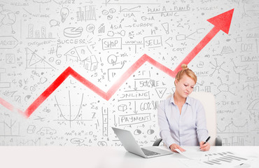 Business woman sitting at table with market diagrams