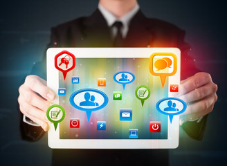 Businessman presenting modern tablet with colorful social signs