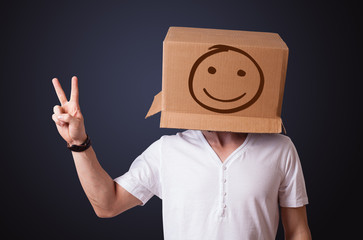 Young man gesturing with a cardboard box on his head with smiley