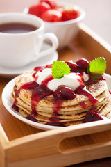 pancakes with cherry jam and cream for breakfast