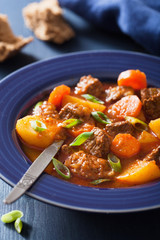 beef stew with potato and carrot in blue plate