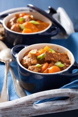 beef stew with potato and carrot in blue pots