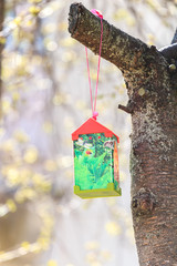Paper bird feeder on cherry tree in sunny day