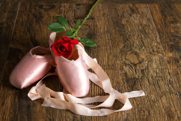 Old used ballet slippers lying on floor with rose and petal © Alta Oosthuizen