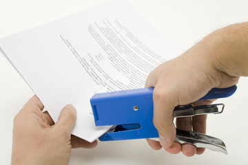 Stapling a document / Stapler and a stack of papers.
