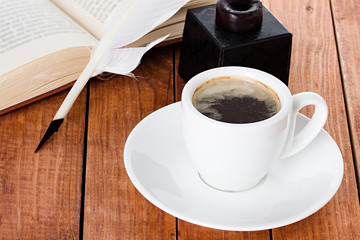 cup of coffee with a quill pen and inkwell