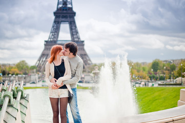 Loving couple kissing near the Eiffel Tower in Paris