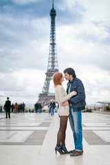 Fototapeta premium Loving couple kissing near the Eiffel Tower in Paris