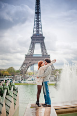 Fototapeta na wymiar Loving couple kissing near the Eiffel Tower in Paris