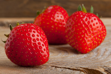 Three strawberries on wood
