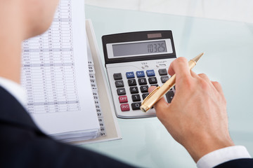 Businessman Holding Calculating Expense In Office