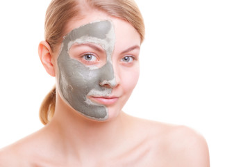 Skin care. Woman applying clay mask on face. Spa.