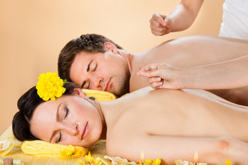 Obraz na płótnie Canvas Couple Receiving Acupuncture Treatment At Spa