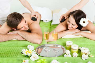 Obrazy na Szkle  Para korzystających z masażu gorącymi kamieniami w spa