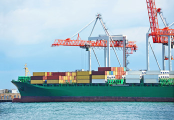 Container stack and ship under crane bridge