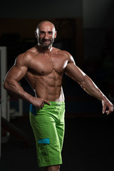 Fototapeta na wymiar Mature Muscular Man Flexing Muscles