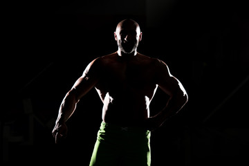 Fototapeta na wymiar Siluet Muscular Man Flexing Muscles