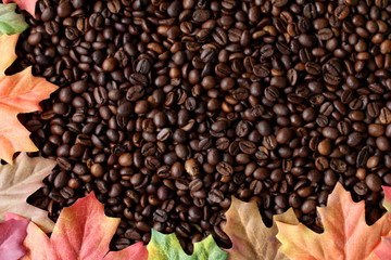 Kaffeebohnenhintergrund mit Herbstblättern