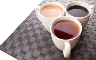 Hot beverages of chocolate, tea and black coffee on woven place 