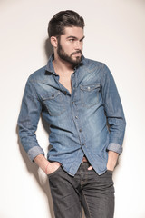 side view of a relaxed young man in jeans clothes