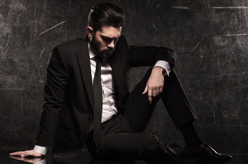 sad young bearded business man looking down