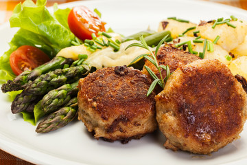 Meatballs served with boiled potatoes and asparagus