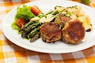 Meatballs served with boiled potatoes and asparagus