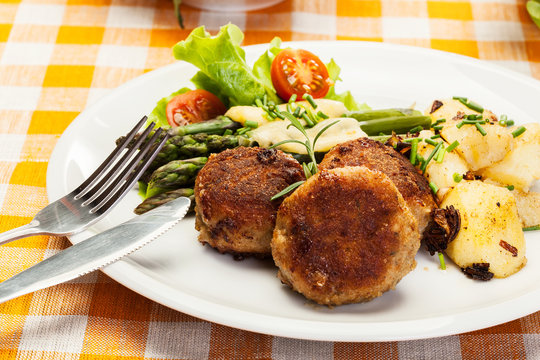 Meatballs served with boiled potatoes and asparagus