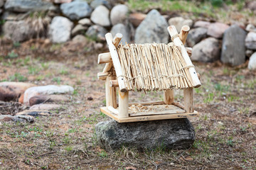Handmade wooden bird house standing on rock
