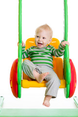 baby boy playing on the swings