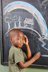 Afrikanischer Junge malt an Tafel