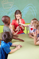 Erzieher spielt Flöte im Kindergarten