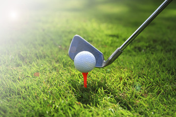 Golf ball on tee in front of driver