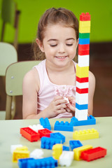 Mädchen spielt mit Bausteinen im Kinderzimmer
