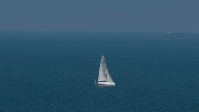 Sailing boat in open blue sea, top view