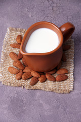 Almond milk in jug with almonds in bowl,
