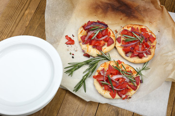 Small pizzas on baking paper close up