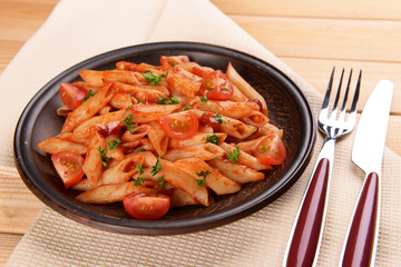 Pasta with tomato sauce on plate on table close-up