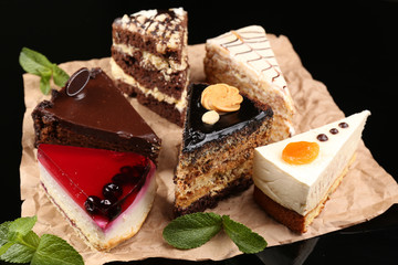 Assortment of pieces of cake, on dark background © Africa Studio