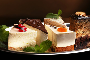 Assortment of pieces of cake, on dark background © Africa Studio