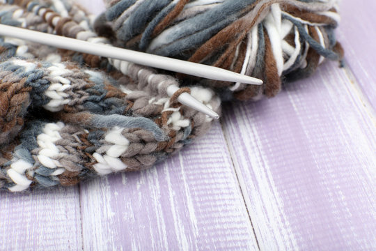 Knitting with spokes on wooden background