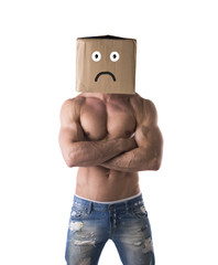 Muscular shirtless bodybuilder with sad box on head