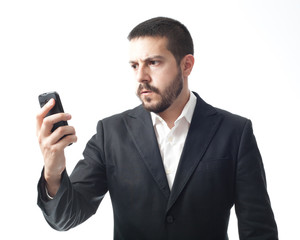 Naklejka premium Angry young businessman looking mobile phone.