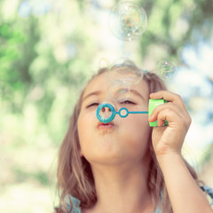 Little girl blowing soap bubbles