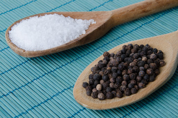 Salt and pepper in wooden spoons