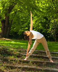 Young attractive woman doing yoga in nature
