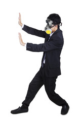 Fototapeta na wymiar Businessman with a gas mask pushing something