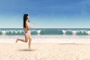Fototapeta na wymiar Happy woman jogging on the beach
