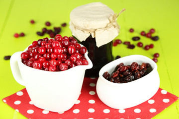 Fresh and dry cranberry in pitchers and bowl